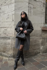 a lady in a black dress and a long wool coat